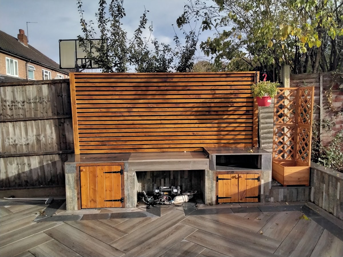A finished garden by Peak Fencing and Landscaping with slatted cedar screening and porcelain paving