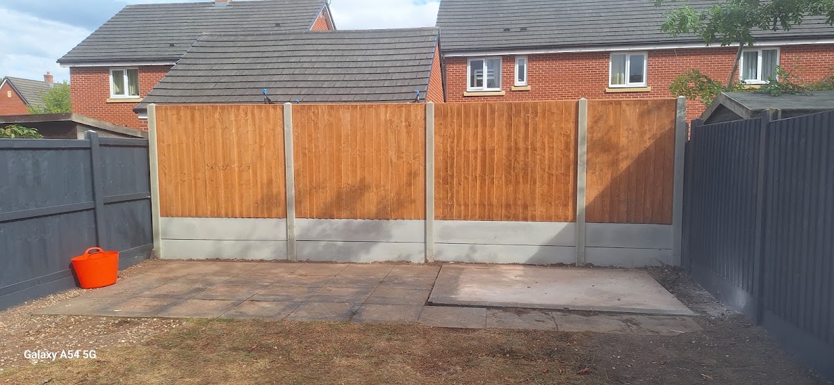 New close-board fence panels on concrete gravel boards beside fresh paving