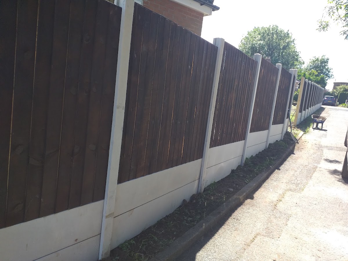 Dark-stained featheredge fencing running along a driveway